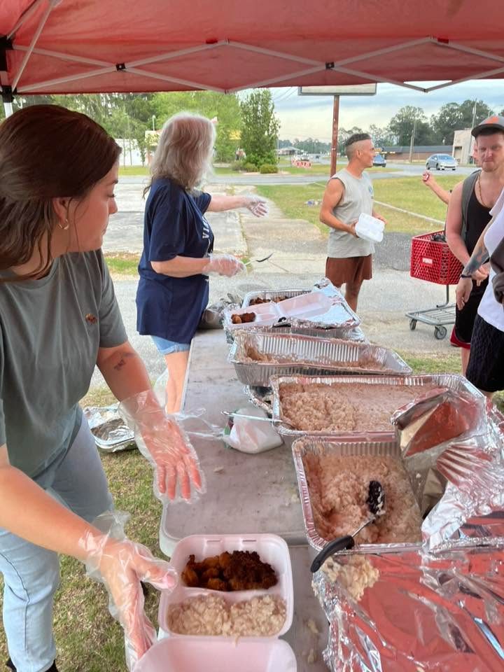 Volunteers serving plates of food at the Moultrie Street Feed