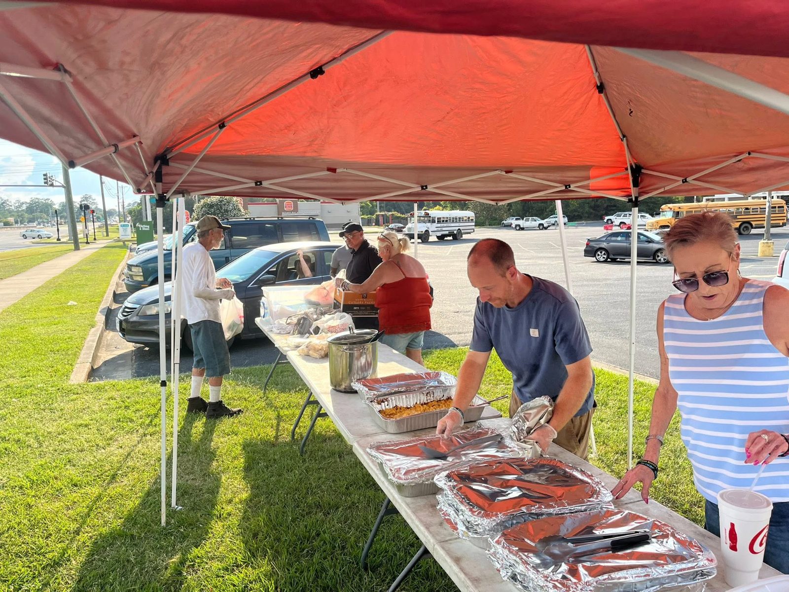Hope Ministry volunteers serving hot meals under the tent at a Moultrie Street Feed