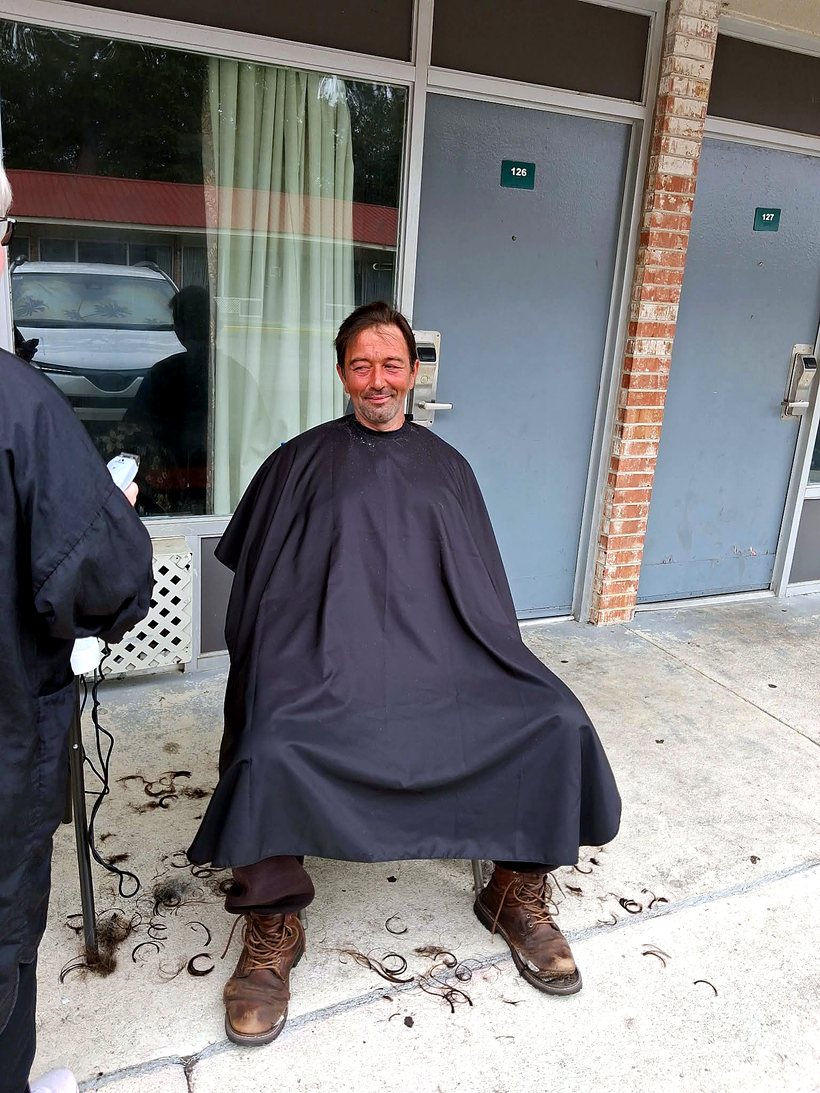 A guest smiling after a fresh haircut on Tuesday Shower Day